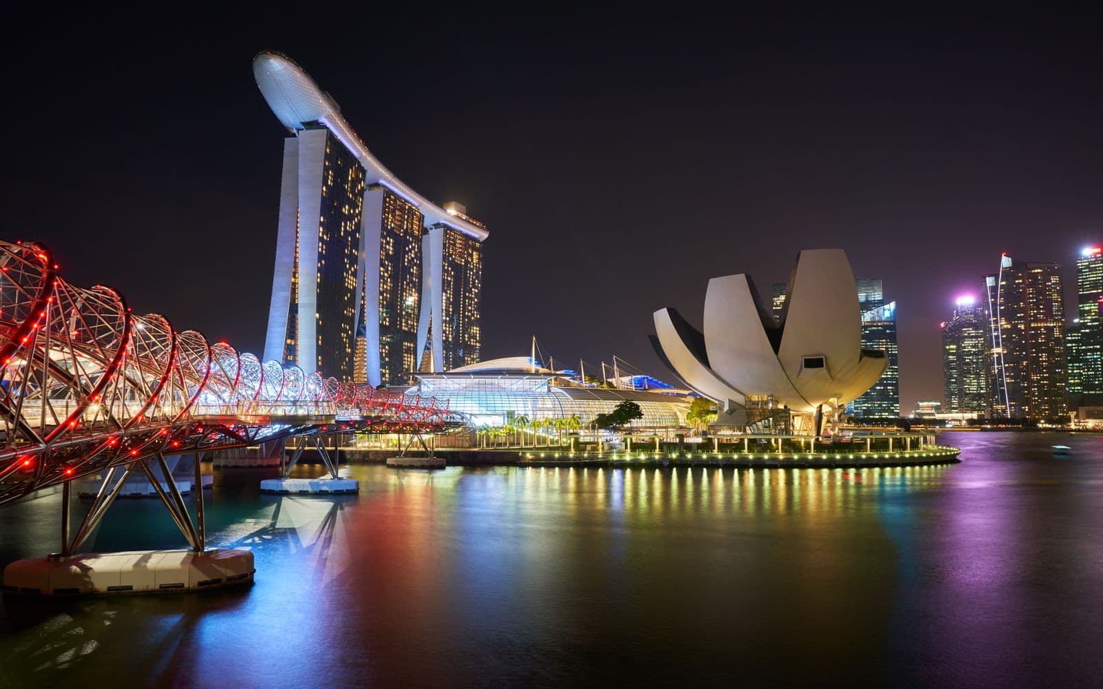 Marina Bay Sands and Helix Bridge illuminated over the water at night, Singapore