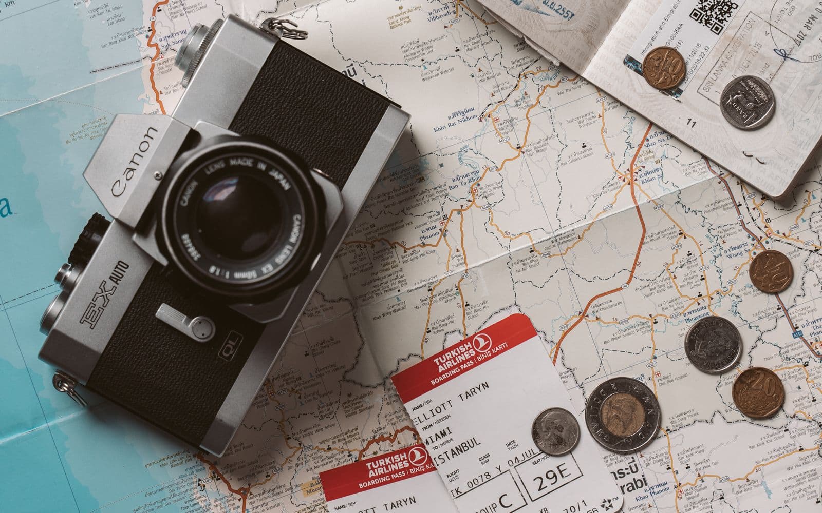 Passports, tickets and a camera laid out over a world map